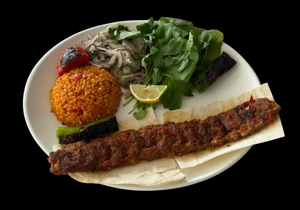 Adana kebap; lavaş, bulgur pilavı, sumaklı soğan ve köz sebzelerle